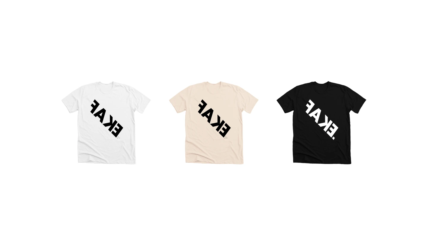 Three FAKE-branded tees in white, sand, and black laid out on a white background.