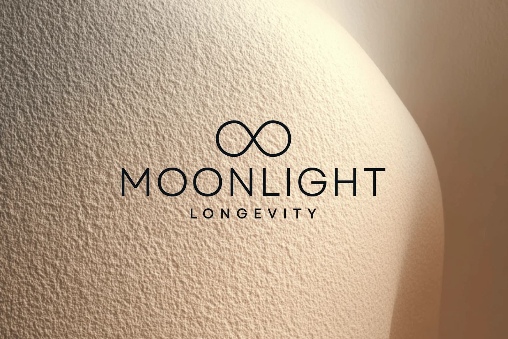The Moonlight Longevity wordmark on a softly lit, sculpted plaster wall.
